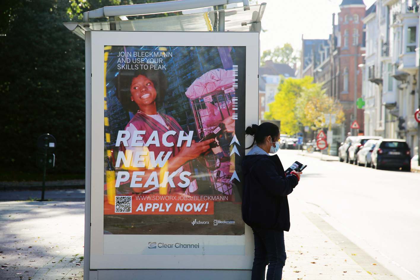 Mockup of a Banner on a bus shelter for SD Worx: Bleckmann is ready to peak. Version with a woman typing something into a scanning machine