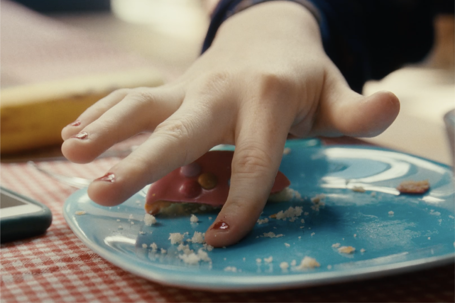 Fingers taking the last pieces of food on a plate