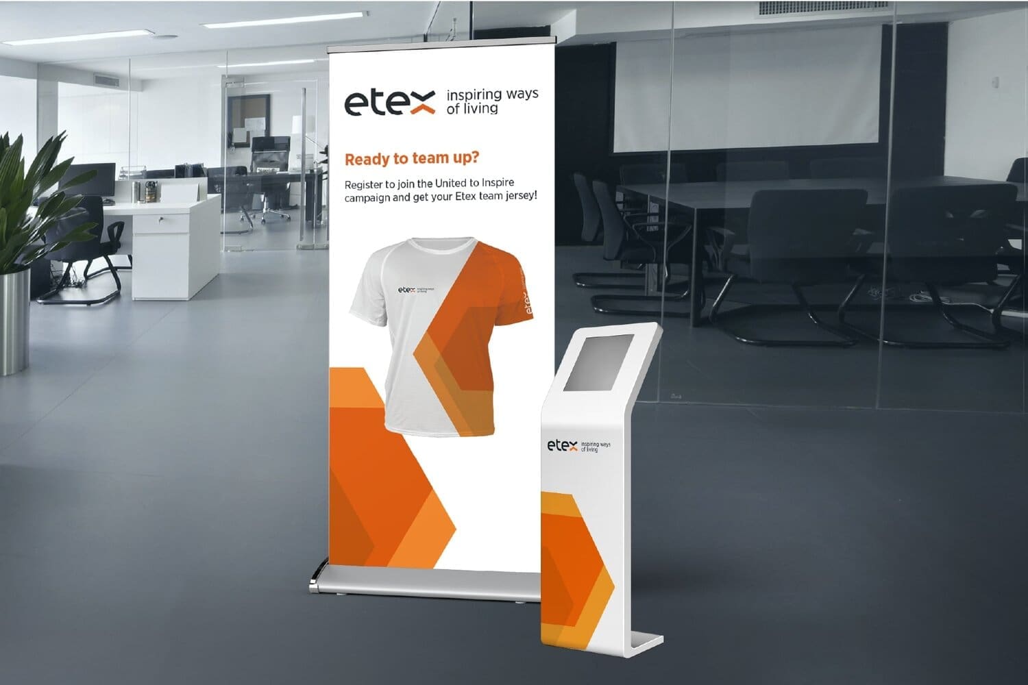 Etex roll-up banner and branded kiosk promoting the "United to Inspire" campaign with a team jersey in an office setting