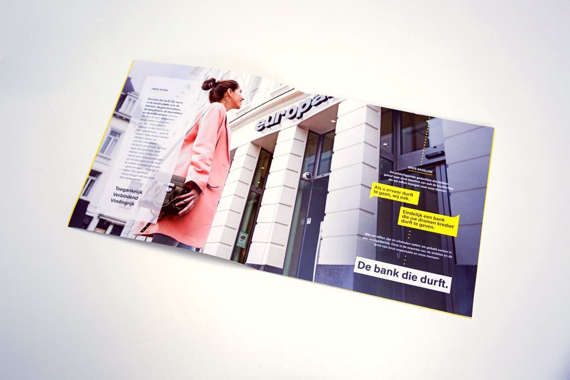 Europese brochure 'De bank die durft' met vrouw in roze jas voor bankgebouw